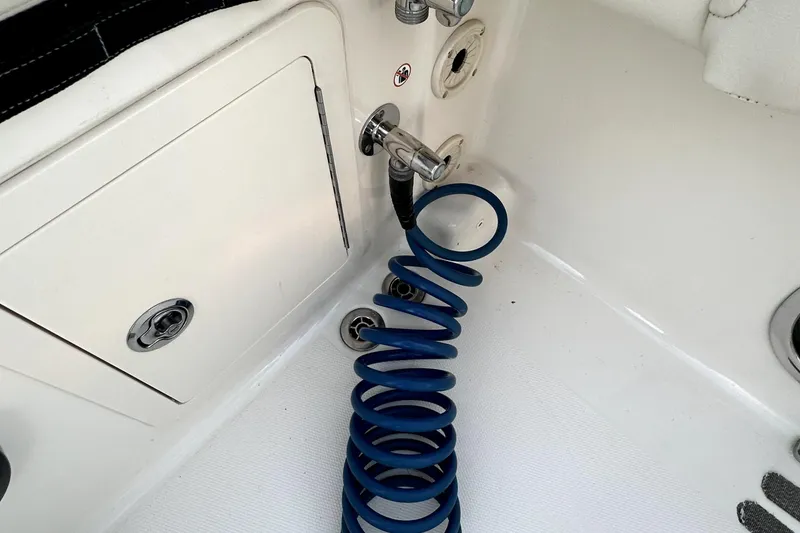 Slide: The Image of Coiled blue hose on 2019 Grady-White Canyon 336 boat deck near storage compartment. - 36