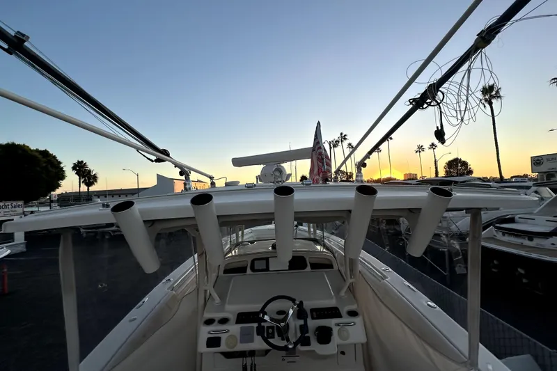 Slide: The Image of 2019 Grady-White Canyon 336 boat at sunset, showcasing helm and rod holders. - 44
