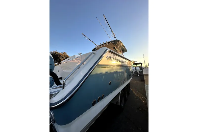 Slide: The Image of 2019 Grady-White Canyon 336 boat, docked at sunset, showcasing sleek design and fishing rods. - 5