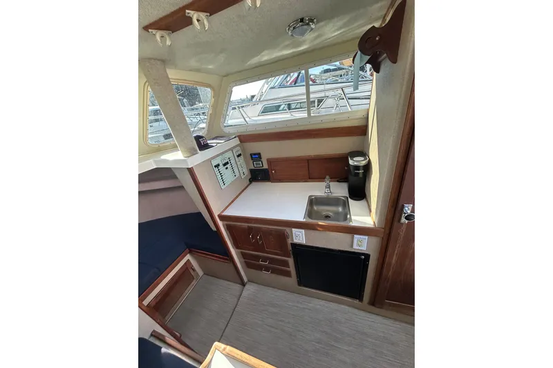 Slide: The Image of Interior of 1998 Blackman Billfisher 26 boat with kitchenette and seating area. - 12