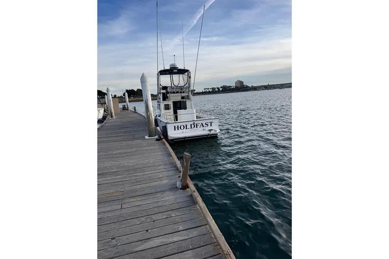 Slide: The Image of Docked 1998 Blackman Billfisher 26 boat named "Holdfast" on a calm waterfront. - 6