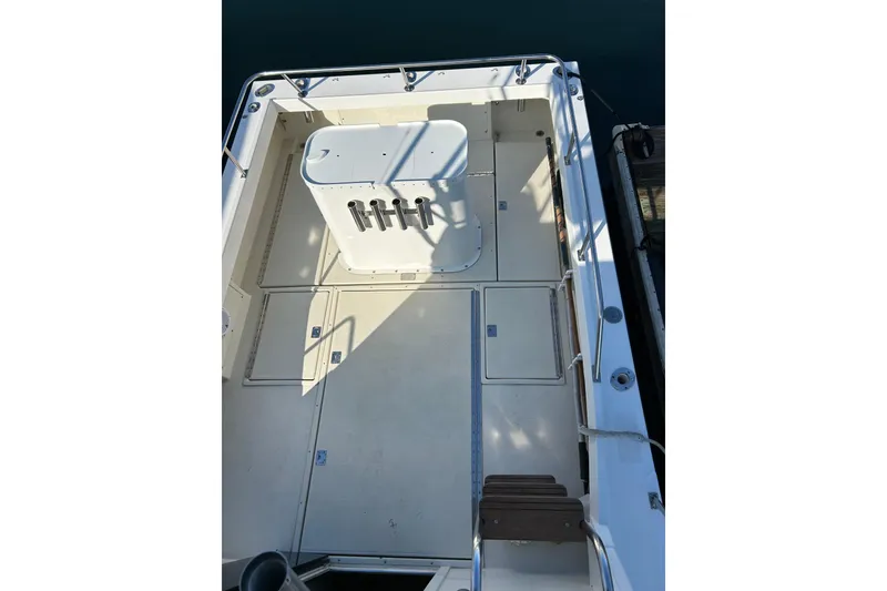 Slide: The Image of 1998 Blackman Billfisher 26 boat deck with rod holders and storage compartments. - 8