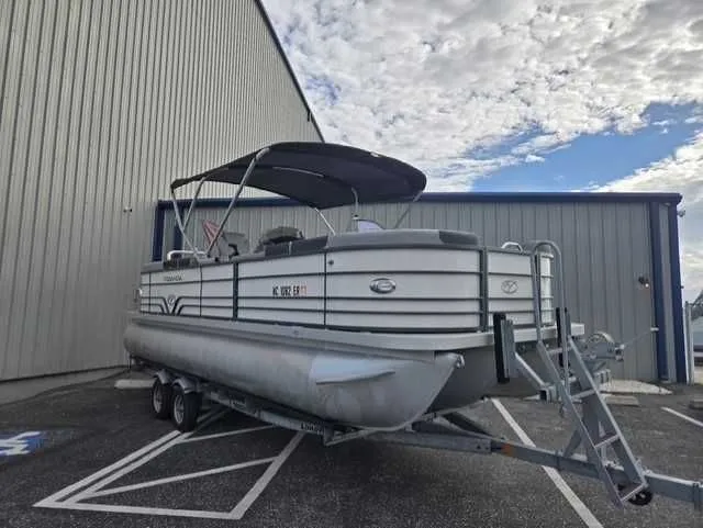 Slide: The Image of 2020 Veranda VTX22RC pontoon boat on trailer, parked near a large building. - 10
