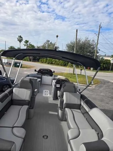 Slide: The Image of 2020 Veranda VTX22RC pontoon boat with spacious seating and canopy, parked outdoors. - 7