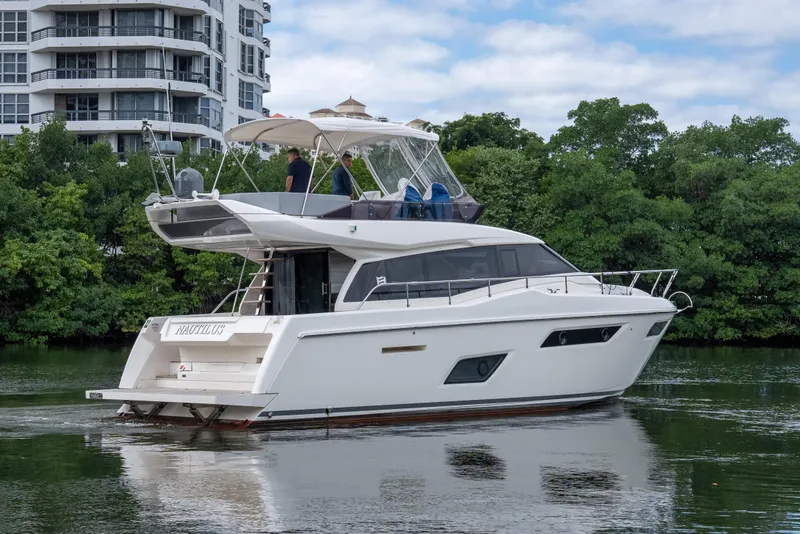 Slide: The Image of 2018 Ferretti Yachts 450 Fly cruising near modern buildings and lush greenery. - 33