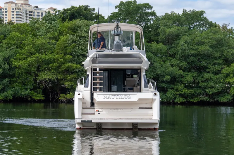 Slide: The Image of 2018 Ferretti Yachts 450 fly cruising on a serene river, surrounded by lush greenery. - 34