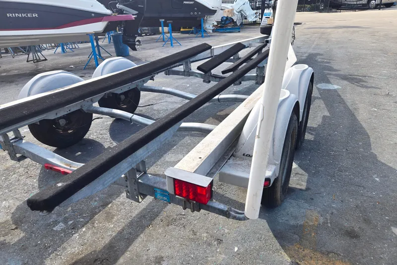 Slide: The Image of 2013 EZ Loader 21-25 trailer with dual axles in a boatyard setting. - 2