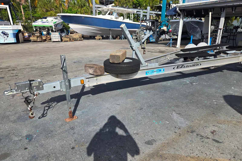Slide: The Image of 2013 EZ Loader 21-25 trailer in a boatyard, featuring dual axles and sturdy construction. - 4