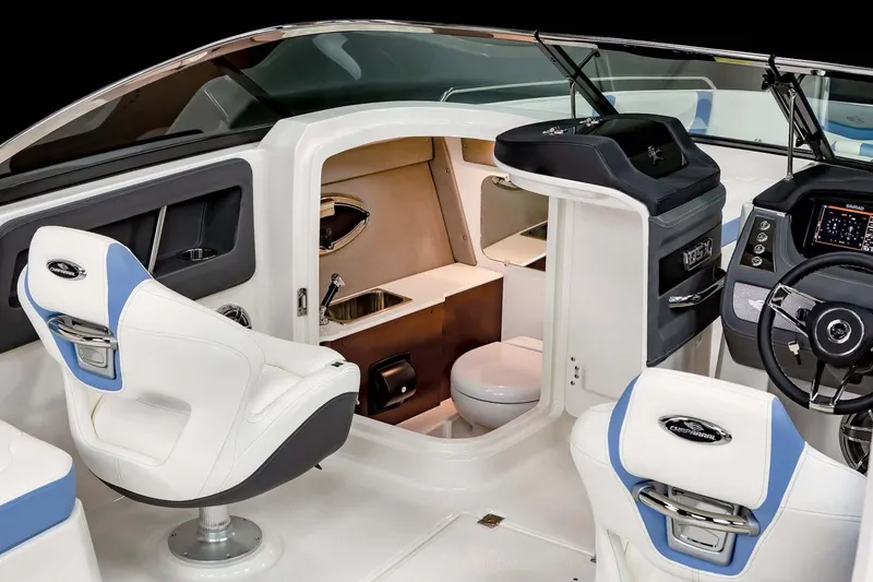 Slide: The Image of 2026 Chaparral 250 OSX boat interior at an indoor exhibition, featuring sleek seating and surfboard storage. - 7
