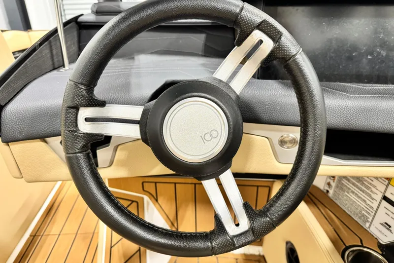 Slide: The Image of Steering wheel of 2025 Nautique Super Air Nautique G21 boat, featuring sleek design. - 10