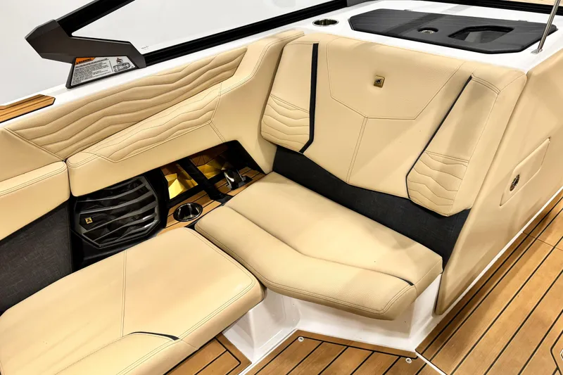 Slide: The Image of 2025 Nautique Super Air Nautique G21 interior with beige leather seating and wood accents. - 11