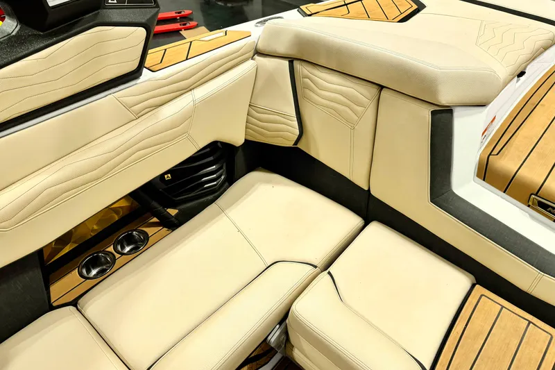 Slide: The Image of 2025 Nautique Super Air Nautique G21 interior with beige upholstery and wood accents. - 13