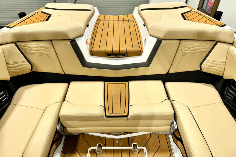 Slide: The Image of 2025 Nautique Super Air Nautique G21 interior with beige seating and teak accents. - 14