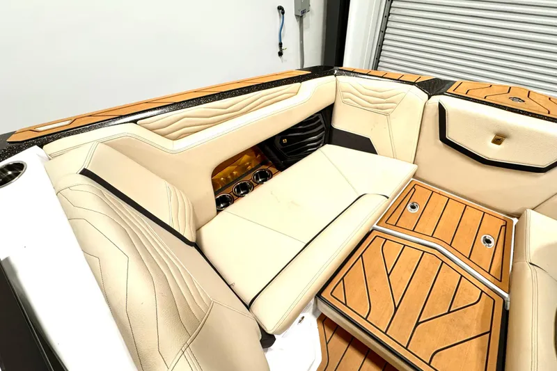 Slide: The Image of 2025 Nautique Super Air Nautique G21 interior with luxurious seating and teak flooring. - 16