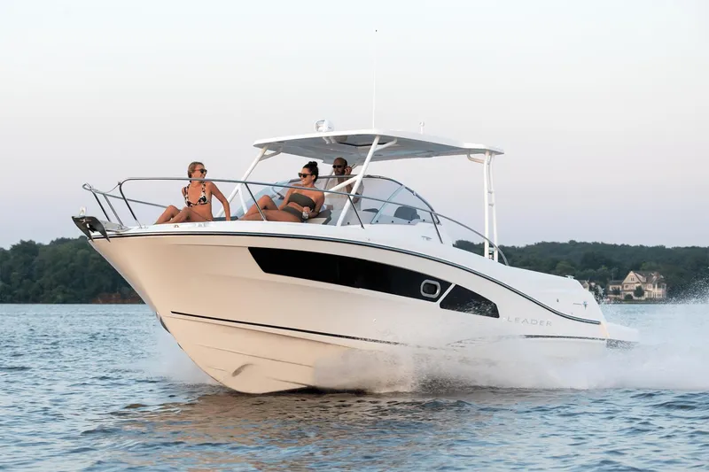 The Image of 2024 Jeanneau Leader 9.0 WA boat on trailer, blue and white design. - 0