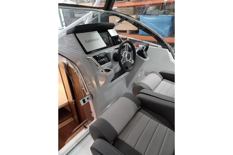 Slide: The Image of 2024 Jeanneau Leader 9.0 WA cockpit with Garmin navigation system and modern seating. - 9