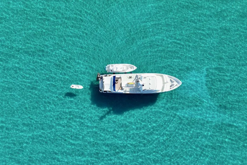 Slide: The Image of Aerial view of 1990 Delta Expedition yacht on clear turquoise water. - 52