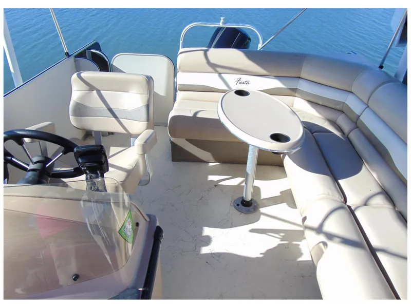 Slide: The Image of 2017 Fiesta 22 Beachcomber boat interior with seating and table on calm water. - 9