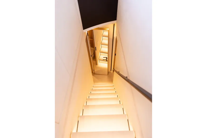 Slide: The Image of Illuminated staircase inside 2025 Bluegame BGM75 yacht, showcasing modern interior design. - 16