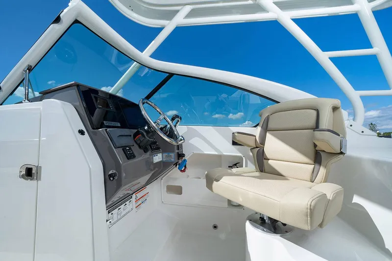 Slide: The Image of Storage compartment on 2026 Pursuit DC 266 Dual Console boat with open drawers and trays. - 16