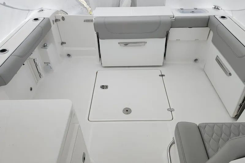 Slide: The Image of 2026 Pursuit DC 266 Dual Console boat interior with gray seating and storage compartments. - 22