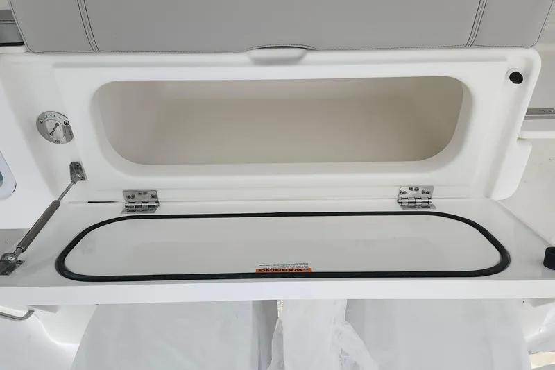 Slide: The Image of Open storage compartment on 2026 Pursuit DC 266 Dual Console boat. - 25