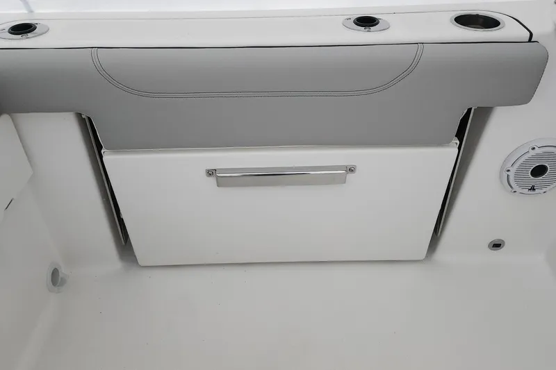 Slide: The Image of 2026 Pursuit DC 266 Dual Console interior detail with storage compartment and cup holders. - 26