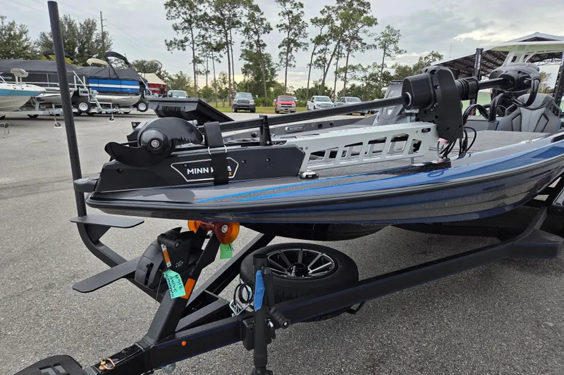 Slide: The Image of 2026 Skeeter FXR21 Apex boat with Minn Kota motor on trailer in parking lot. - 4