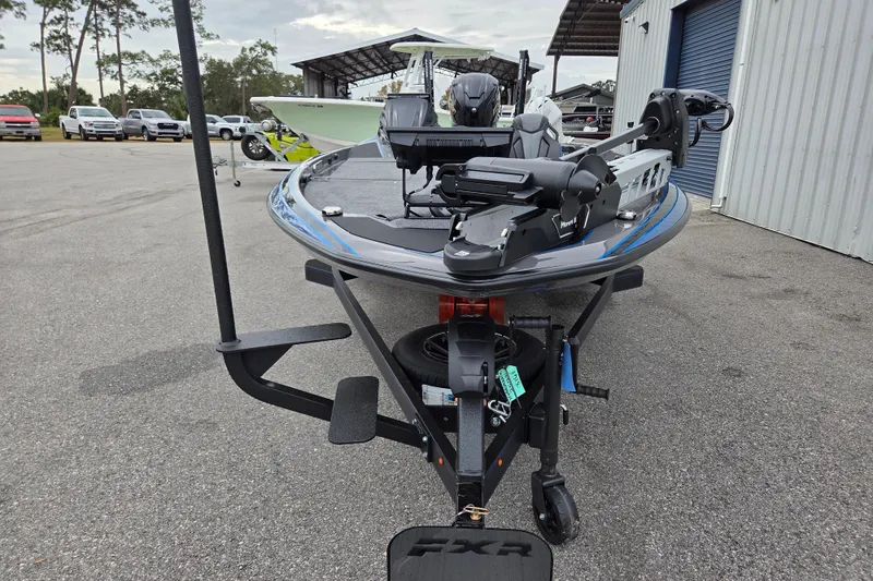 Slide: The Image of 2026 Skeeter FXR21 Apex boat on trailer, parked outdoors near a storage facility. - 9