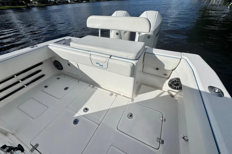 Slide: The Image of 2024 SeaVee 290B boat interior with seating and storage, docked on calm water. - 11