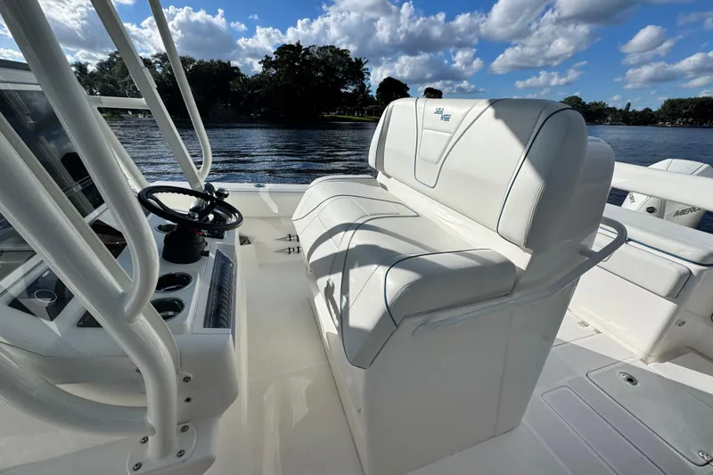 Slide: The Image of 2024 SeaVee 290B boat interior with white seating and steering wheel, on a sunny day. - 15