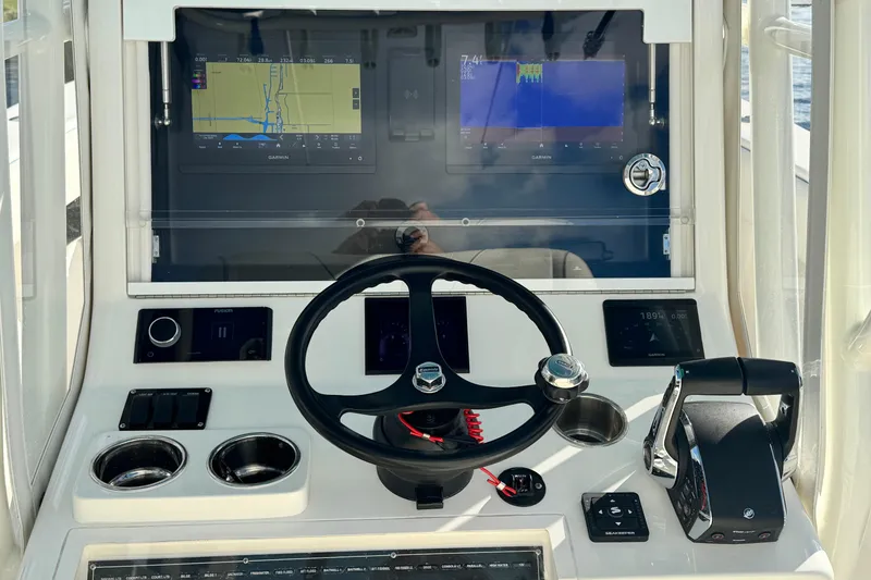 Slide: The Image of 2024 SeaVee 290B boat dashboard with navigation screens and steering wheel. - 16