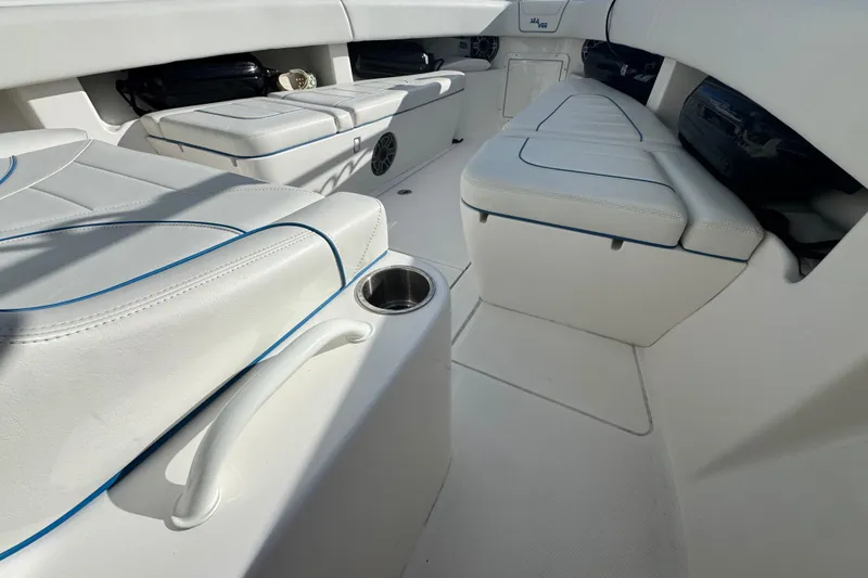 Slide: The Image of 2024 SeaVee 290B boat interior with white cushioned seating and cup holder. - 24