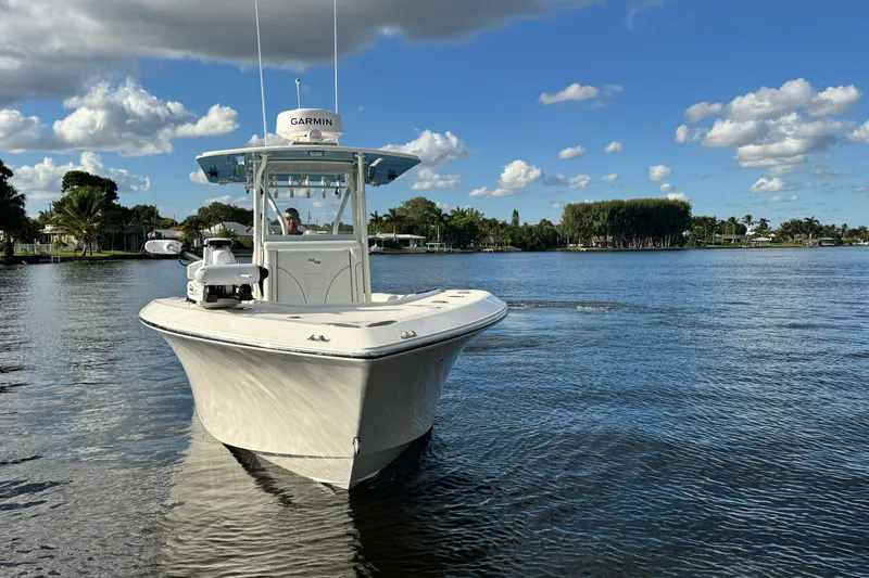 Slide: The Image of 2024 SeaVee 290B boat cruising on a calm lake under a blue sky. - 6