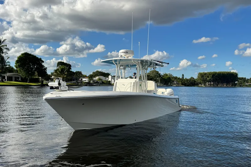 Slide: The Image of 2024 SeaVee 290B boat cruising on a serene lake under a partly cloudy sky. - 8