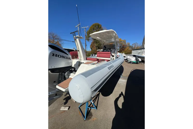 Slide: The Image of 2022 Brig Eagle 8 boat with Honda engine, parked outdoors under clear blue sky. - 11