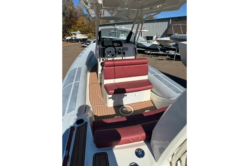 Slide: The Image of 2022 Brig Eagle 8 boat with maroon seating and wood deck, docked outdoors. - 12