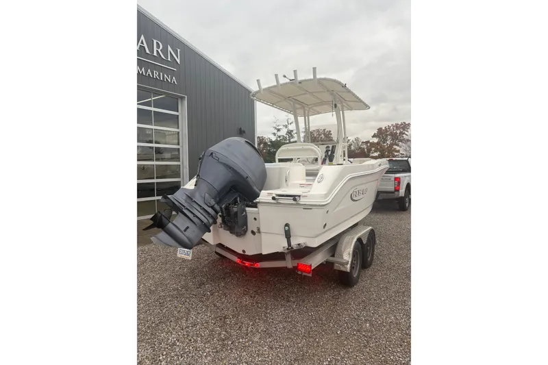 Slide: The Image of 2021 Robalo R202 Explorer boat on trailer, parked outside a marina. - 12