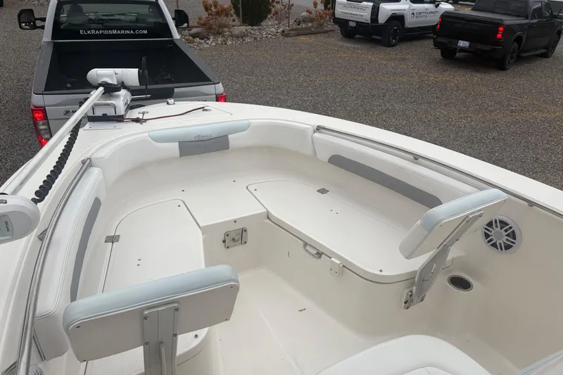 Slide: The Image of 2021 Robalo R202 Explorer boat interior with seating, parked near trucks. - 7