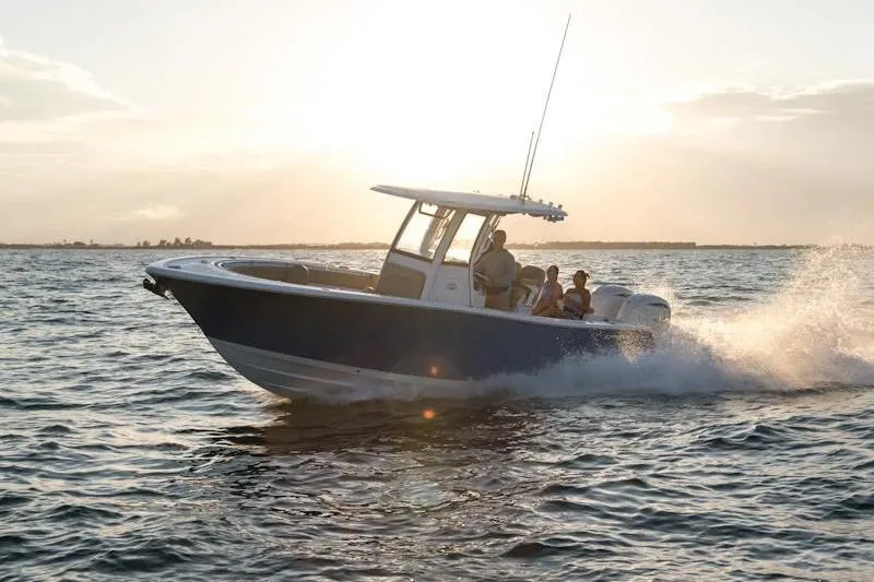 Slide: The Image of 2025 Sportsman Open 252 Center Console boat cruising at sunset on the ocean. - 12