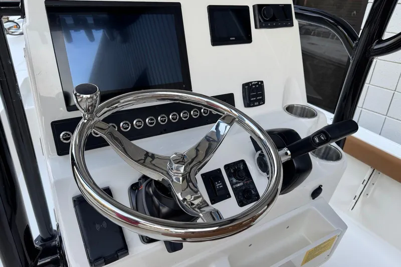 Slide: The Image of 2026 Key West 230 Bay Reef boat console with steering wheel and electronic controls. - 10