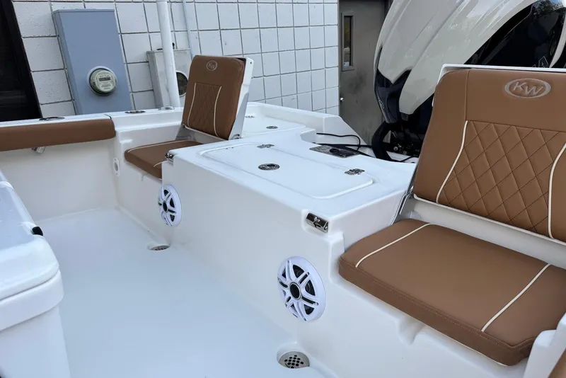 Slide: The Image of 2026 Key West 230 Bay Reef boat interior with brown cushioned seats and white speakers. - 27