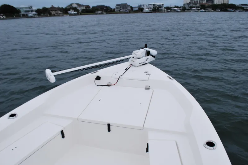 Slide: The Image of 2023 Bay Rider 239 Bay boat on calm waters, featuring a trolling motor. - 10