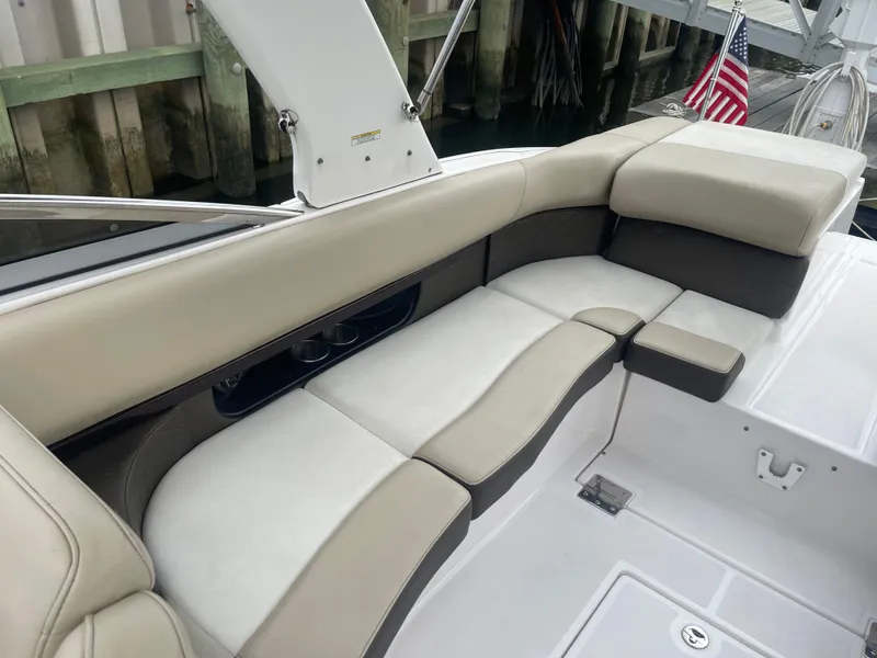 Slide: The Image of 2014 Regal 2700 Bowrider boat interior with beige seating and American flag. - 25