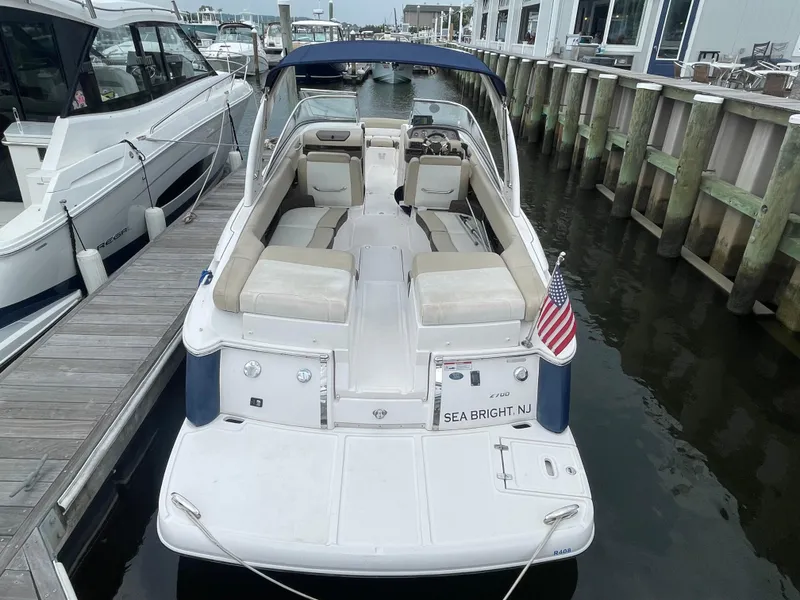 Slide: The Image of 2014 Regal 2700 Bowrider docked, featuring spacious seating and American flag. - 3