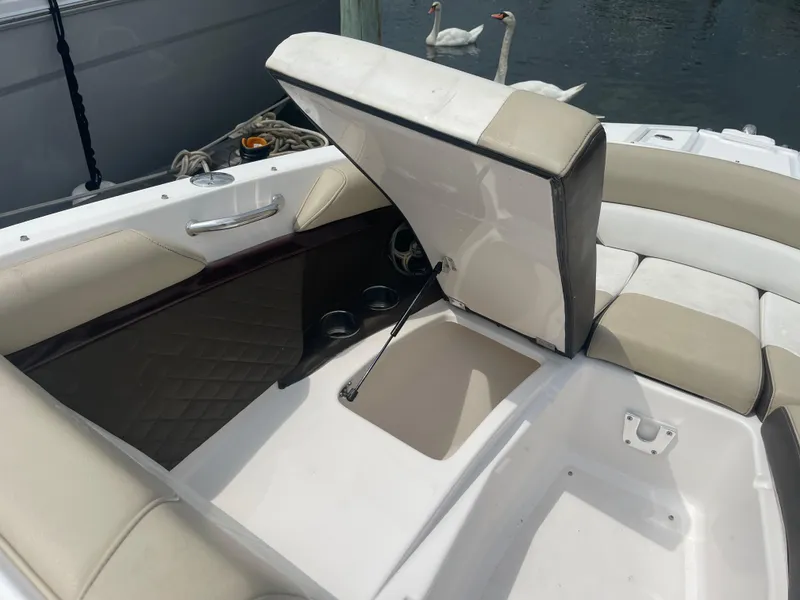 Slide: The Image of 2014 Regal 2700 Bowrider boat interior with open storage compartment and beige seating. - 8