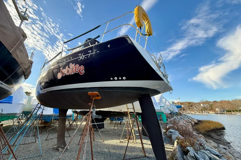 Slide: The Image of 2005 Beneteau First 36.7 sailboat named "Jubilee" on stands by the water. - 10