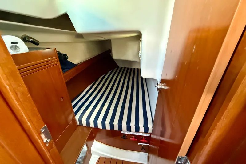 Slide: The Image of 2005 Beneteau First 36.7 cabin interior with striped mattress and wooden finish. - 13
