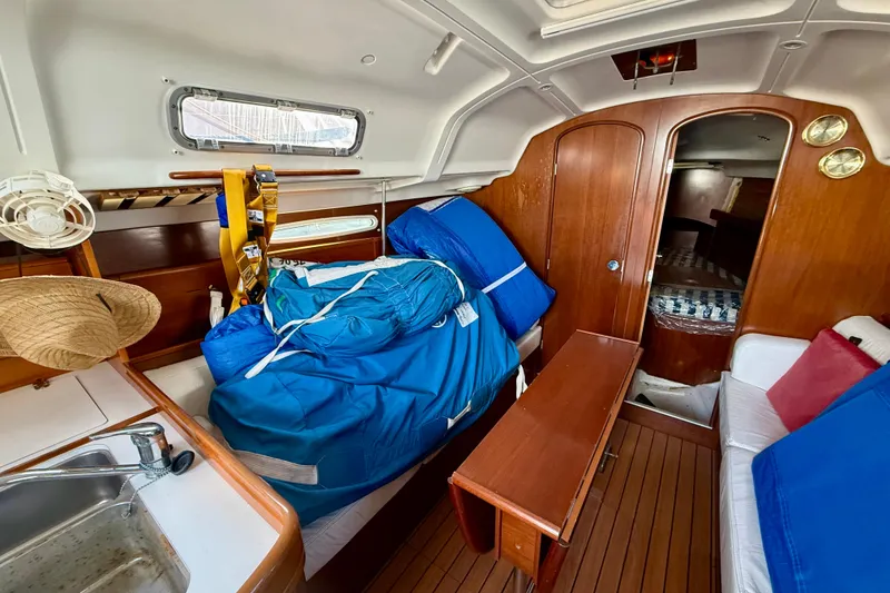 Slide: The Image of Interior of 2005 Beneteau First 36.7 sailboat with wooden finishes and blue sail bags. - 16