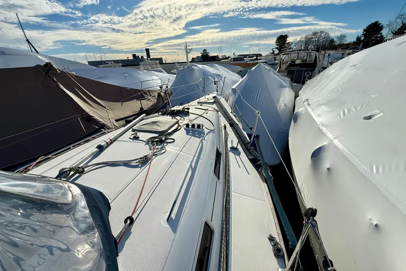 Slide: The Image of Beneteau First 36.7 sailboat, 2005 model, docked among covered boats under a blue sky. - 2